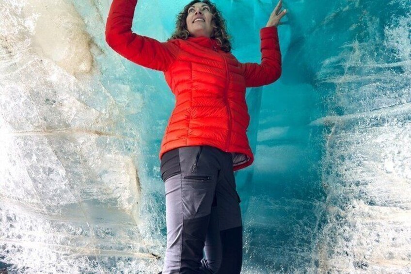 A person in a red jacket inside an ice cave. 2