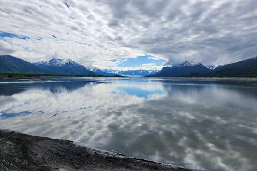 A mountain range, a calm lake, and a cloudy sky. 3