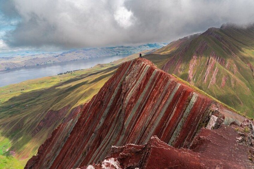 A mountain landscape with a person standing on a ridge. 3