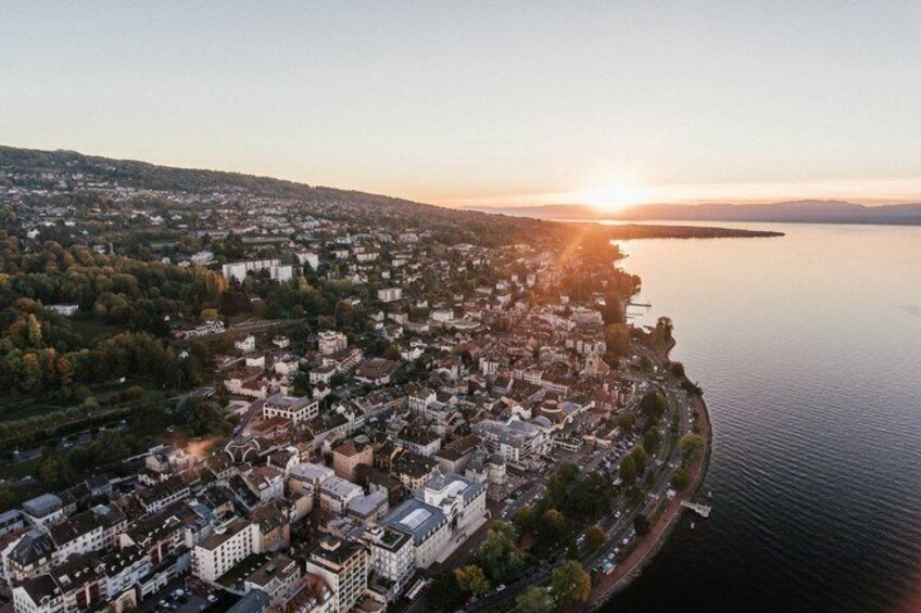 A coastal cityscape with a river, buildings, and a sunset. 1