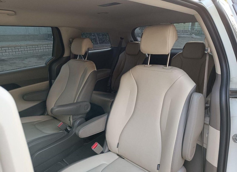 The interior of a car with beige leather seats and a sunroof. 3