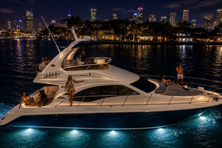 A luxury yacht docked at a marina with a city skyline in the background. 3