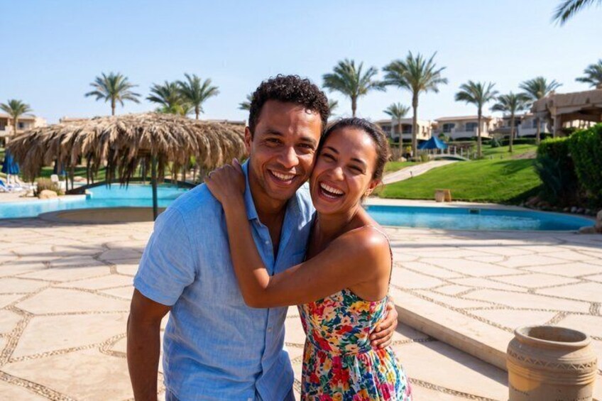 A couple embracing near a pool with palm trees and resort buildings in the background. 1