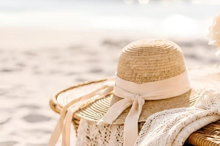 A straw hat with a white ribbon on a beach. 1