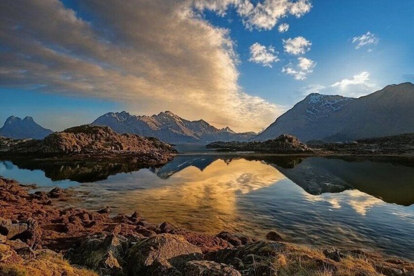 A mountainous landscape with a calm lake reflecting the sky and mountains. 2