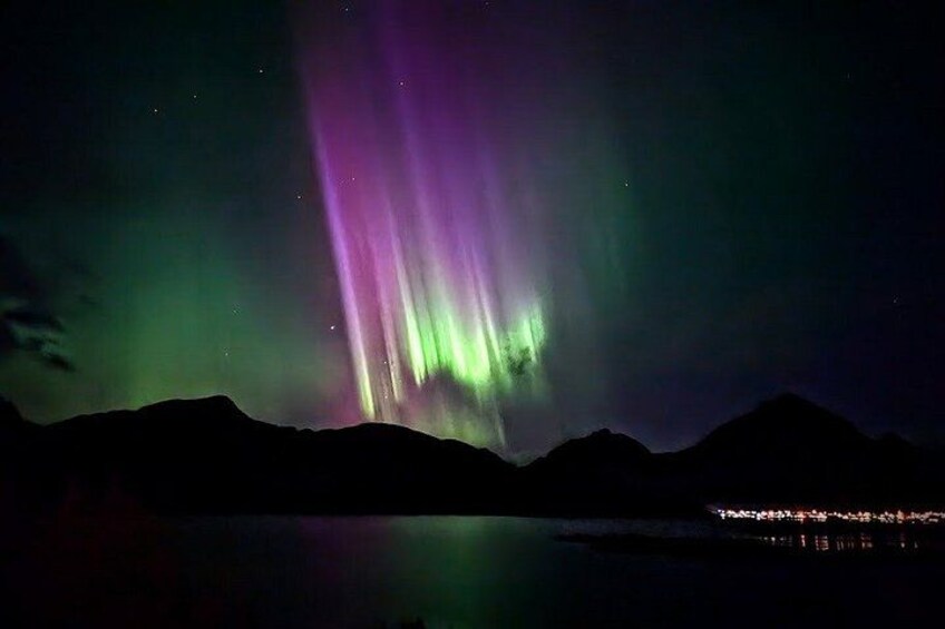 The Northern Lights over a mountainous landscape at night. 4