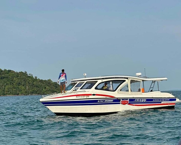 A speedboat on water with a person standing on the deck. 1