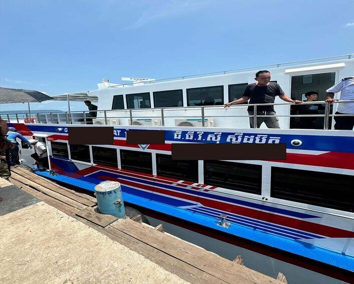 A boat with a blue, red, and white color scheme, docked at a pier. 5