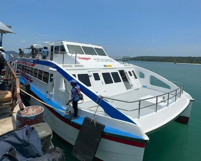 A white boat with blue and red stripes docked at a pier. 4