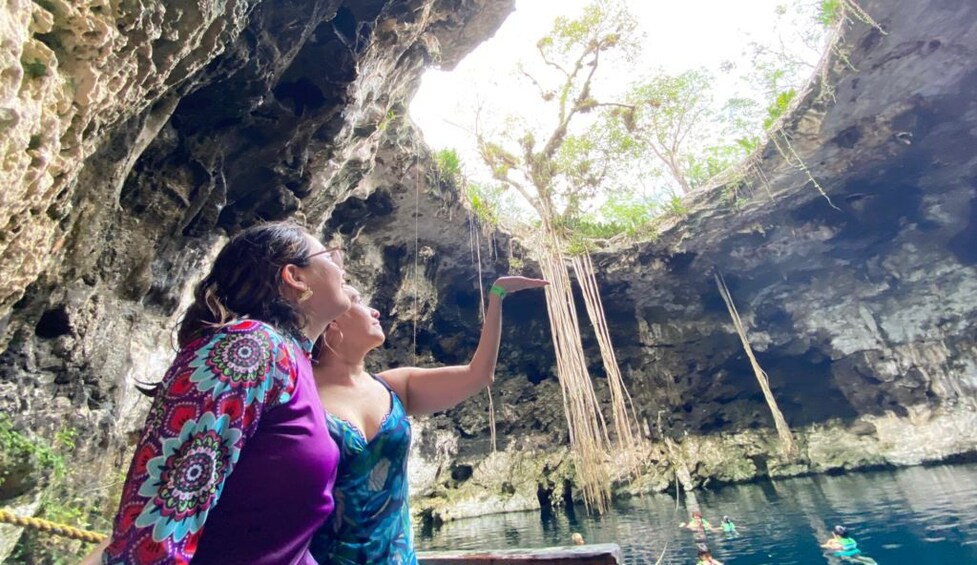 A person reaching out to touch a hanging vine in a cave. 5