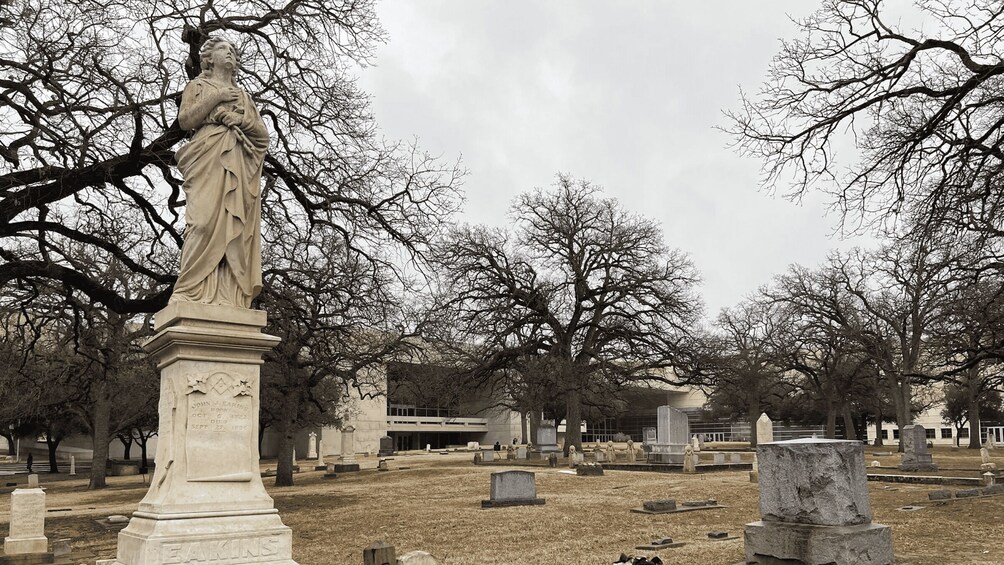 A cemetery with tombstones and a statue. 3
