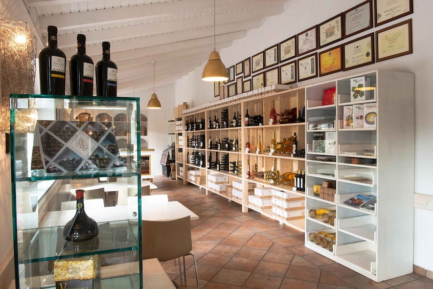 A wine cellar with shelves of bottles and framed certificates on the wall. 5