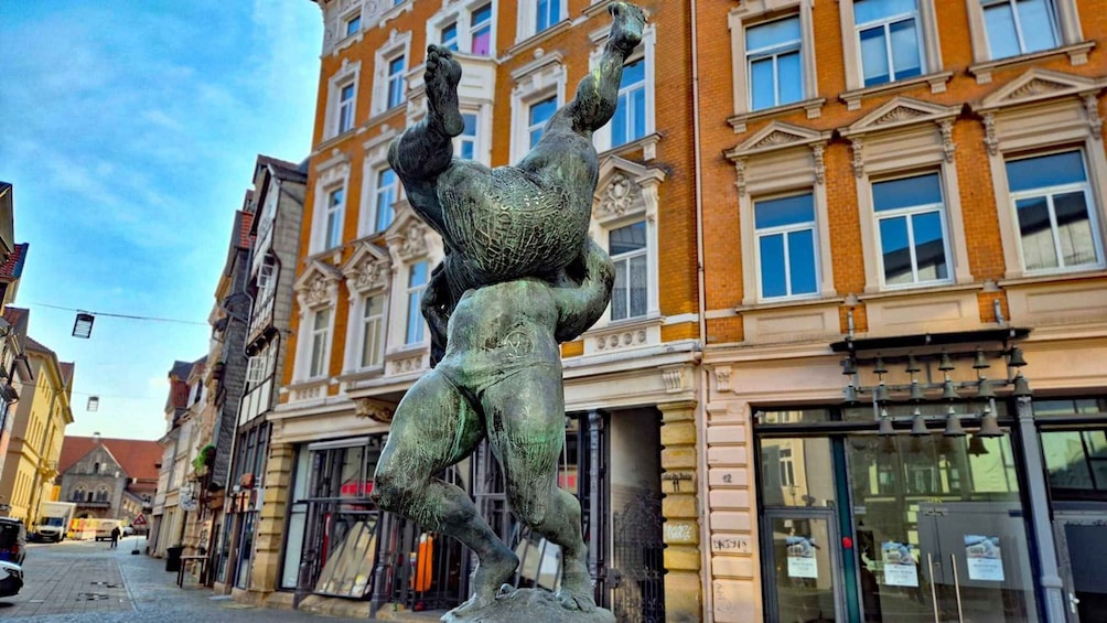 A bronze statue of a man holding a child on a pedestal in an urban setting. 5