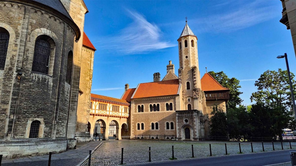 A historic building with a red-tiled roof and a tall tower. 3