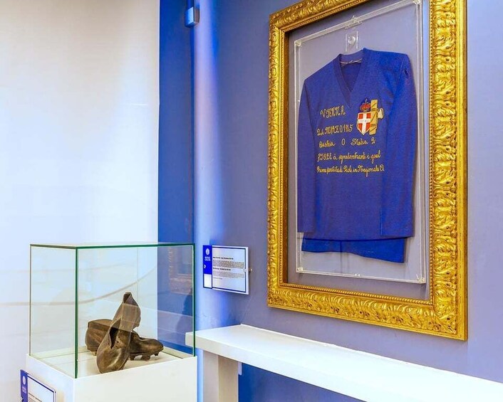 A blue jersey with text and a golden frame on a wall. 5