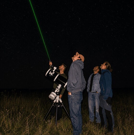 Three people using a telescope to observe the night sky. 5