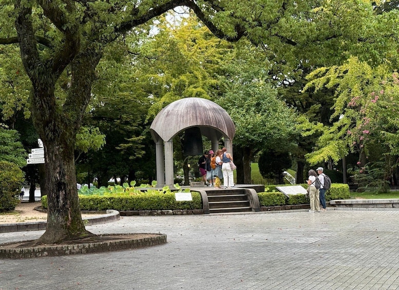 A park with a gazebo, trees, and a paved walkway. 4
