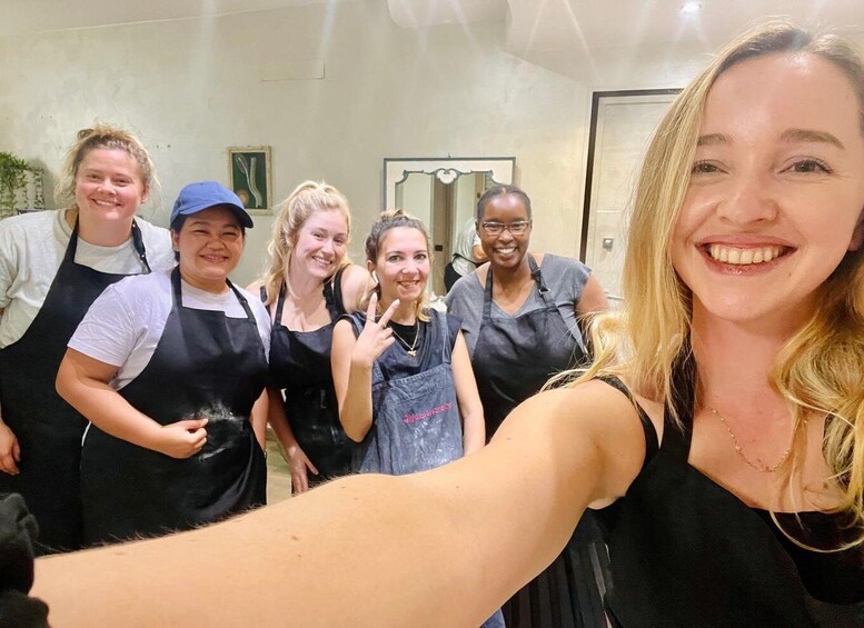 A group of people wearing aprons, suggesting a cooking or baking activity in a kitchen setting. 1
