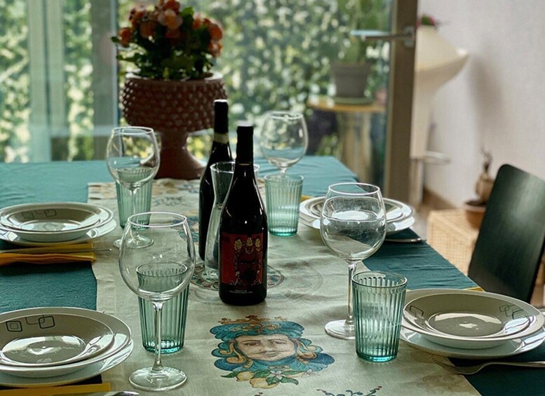 A table set for a meal with wine glasses, plates, and a bottle of wine. 2