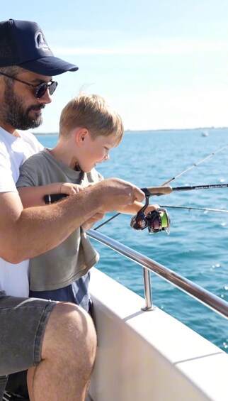 A man and a child fishing on a boat. 1