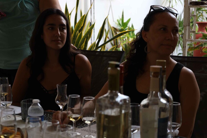 Two people sitting at a table with wine glasses and bottles. 4