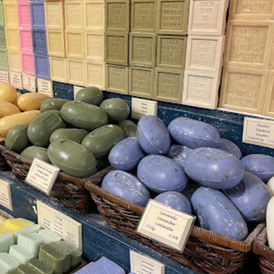 A variety of soaps in different colors and shapes, arranged in baskets and on shelves. 3
