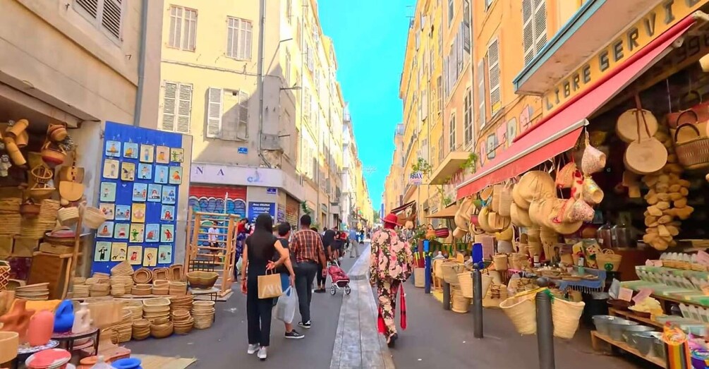 A narrow street lined with shops selling baskets, pottery, and textiles. 1