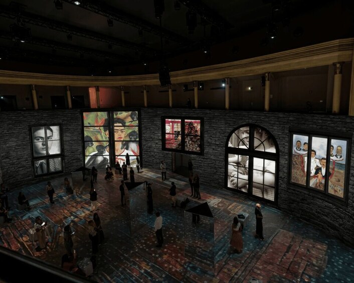 An indoor art gallery with large windows, stone walls, and a patterned floor. 5