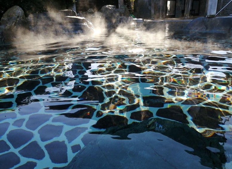 A hot spring with clear water and steam rising from the surface. 3