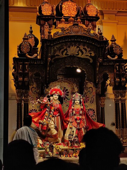 A richly decorated shrine with ornate carvings and two statues. 5
