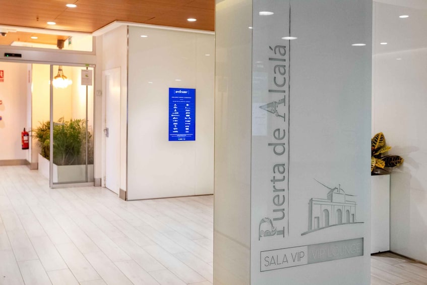 A modern interior with a reception desk, a blue welcome sign, and a glass wall. 4