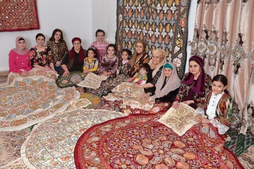 A group of people sitting on patterned carpets in a room with traditional decor. 3