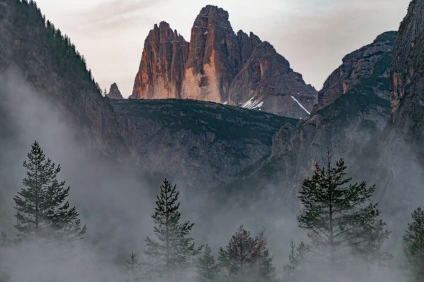 A mountainous landscape with prominent rock formations, dense forest, and a valley. 4