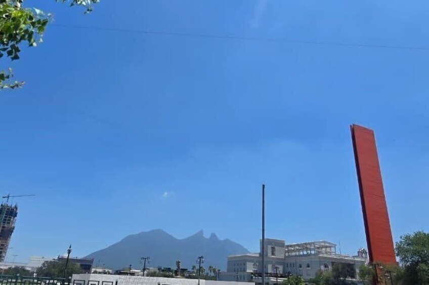 A mountain, a red vertical structure, and a building under construction. 4