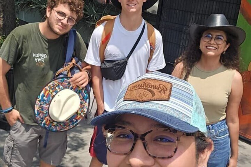 A group of people outdoors, some carrying backpacks and wearing casual clothing. 3