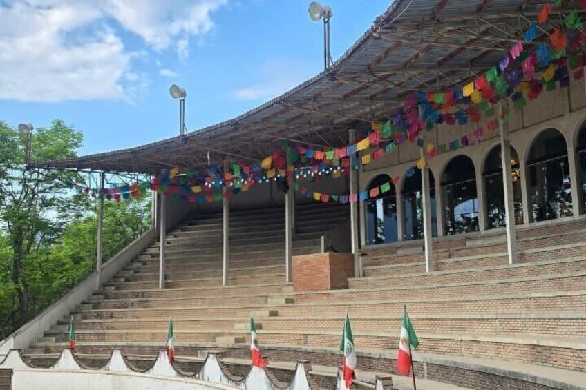 A stadium with tiered seating, flags, and colorful decorations. 2