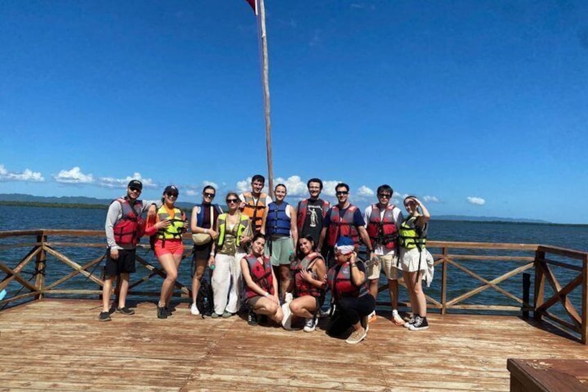 A group of people on a wooden dock by a body of water. 2