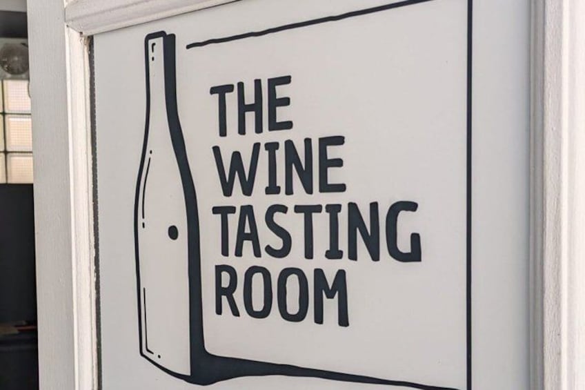 A sign with the text 'THE WINE TASTING ROOM' and a drawing of a wine bottle. 2