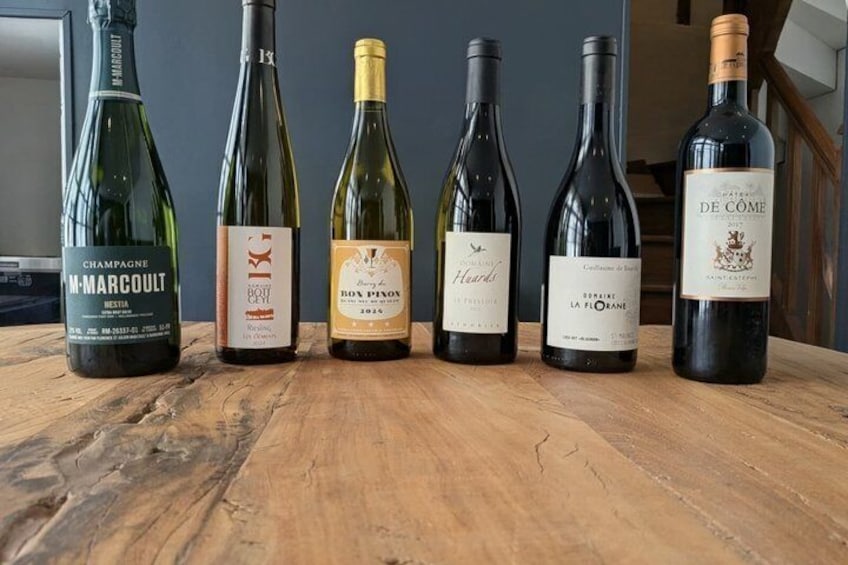 Six wine bottles on a wooden table. 4
