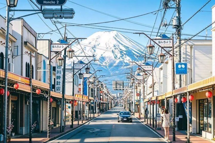 A street with shops, a car, and a mountain in the background. 3