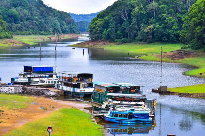 A river with boats docked along the shore, surrounded by lush greenery and hills. 4
