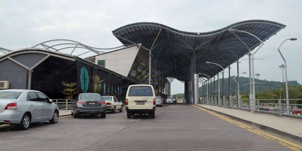 A covered pedestrian bridge with cars parked on the side. 4