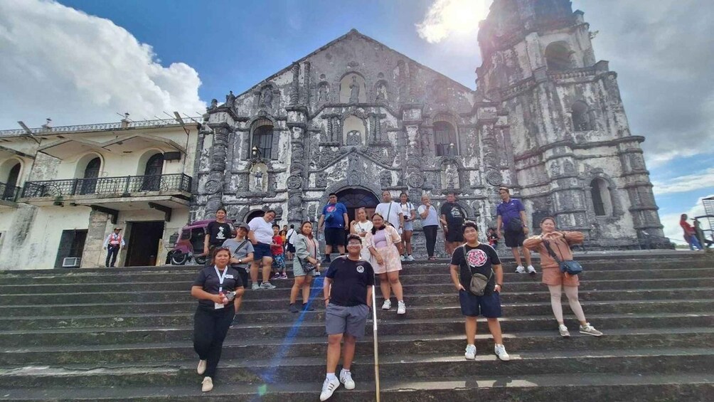 A group of people ascending a set of stone steps towards a historic church with intricate architecture. 1