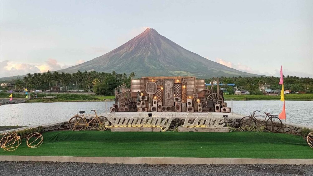 A wooden structure with a sign reading 'Sumatran Love' in front of a volcano. 2