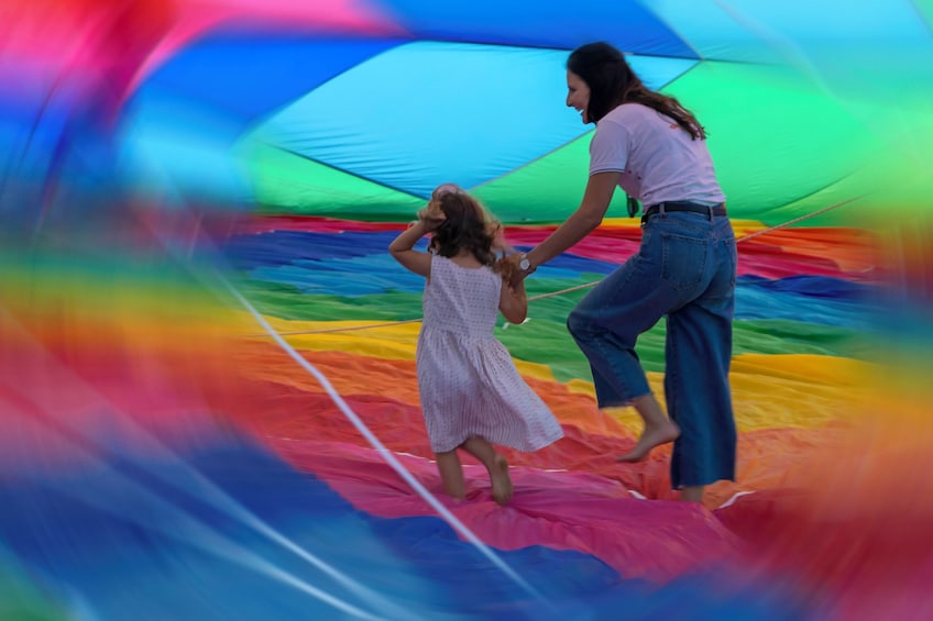 A woman and a child inside a colorful inflatable structure. 4