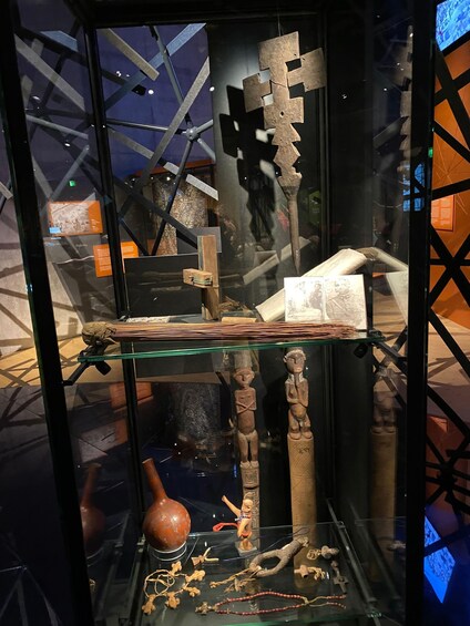 A museum display with glass cases containing various artifacts, including sculptures and decorative items. 1