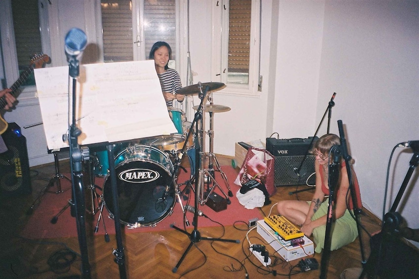 A person playing a drum set with a music stand in front of them. 5