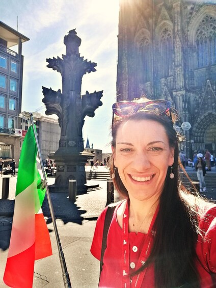 A person holding a flag, a gothic-style monument, and a building with intricate architecture. 1