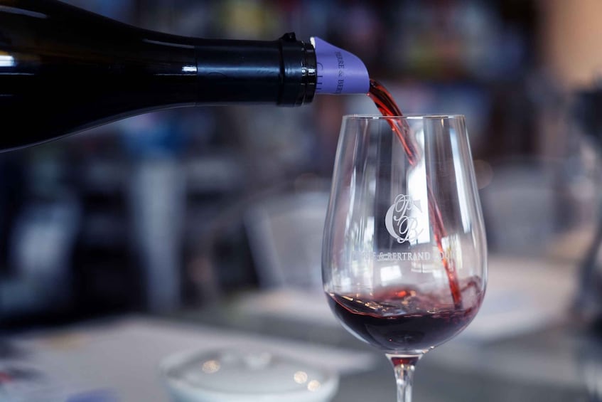 A bottle of wine being poured into a glass. 3
