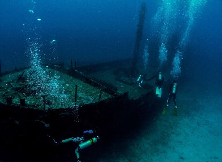 A diver exploring an underwater wreck with bubbles rising to the surface. 2